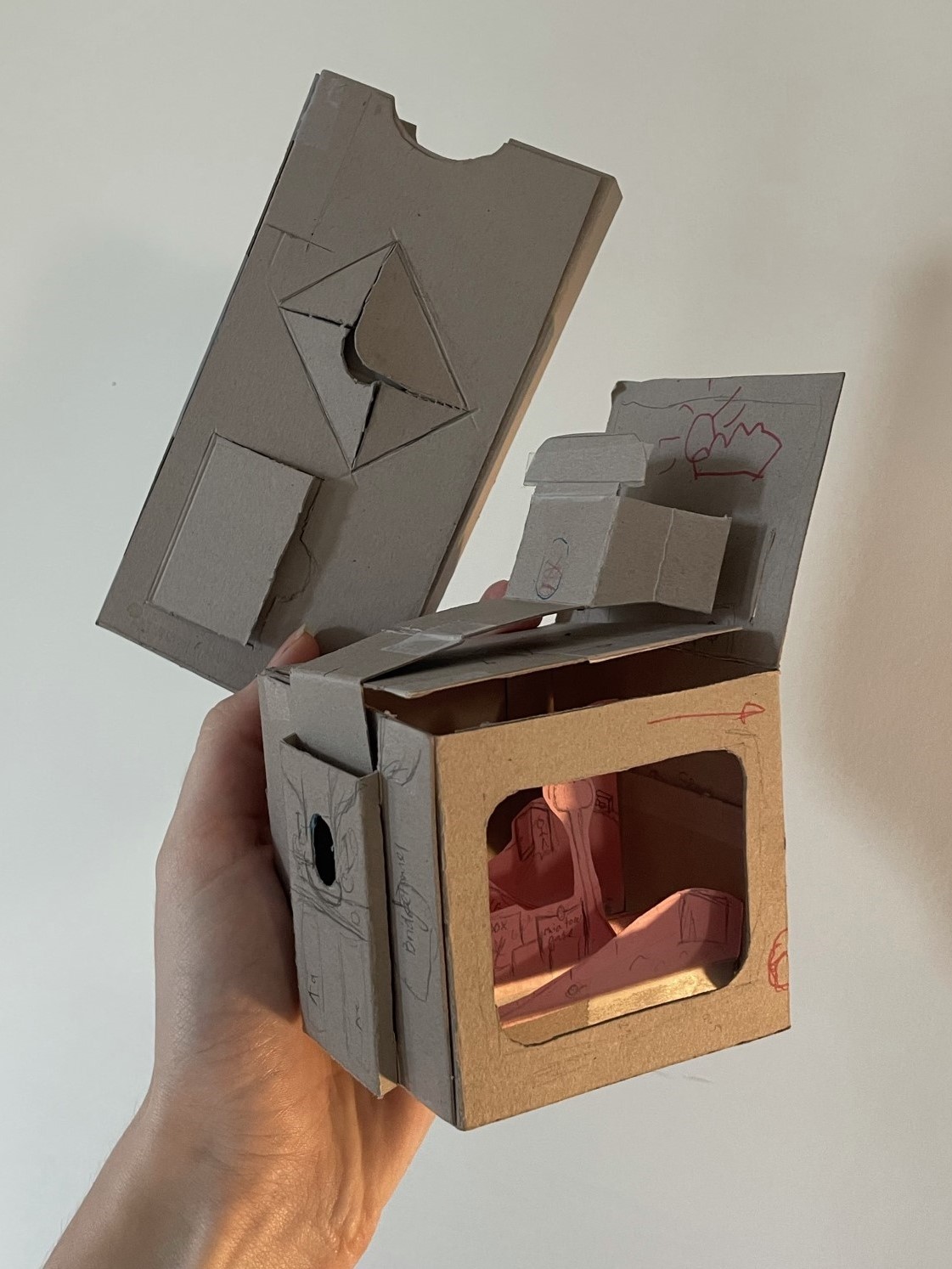 A DIY prototype 
                showing the layered tv scene, the pull-out drive-in scene on top, and the overall sleeve
                 with reveals connected to the digital space.